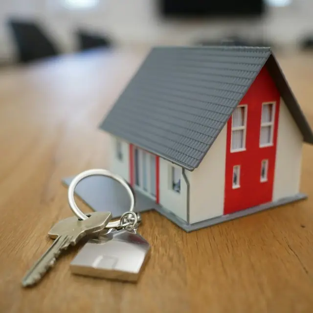 House keys beside a small model house