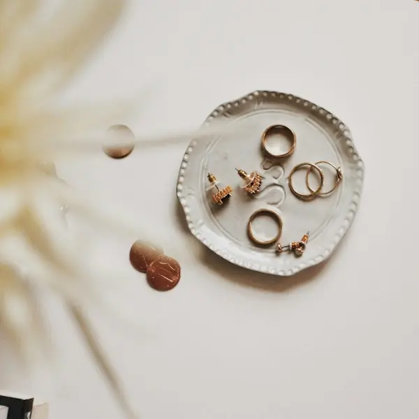 Gold rings and earrings on a ceramic dish