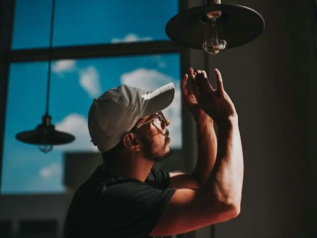 Electrician installing a pendant light bulb
