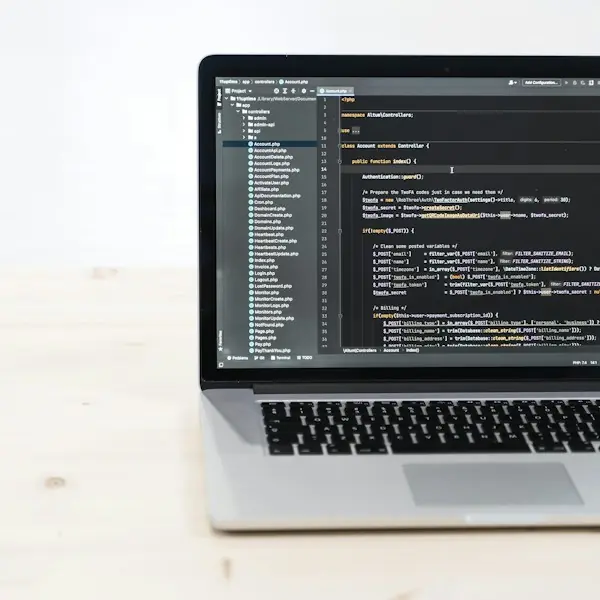 Laptop showing code on a light wooden desk