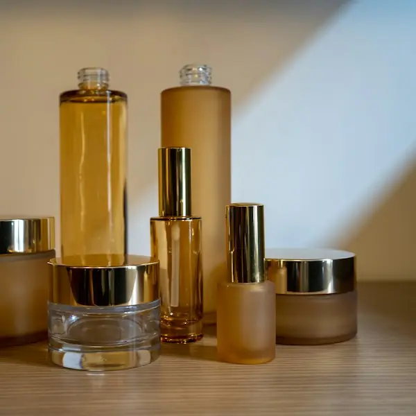 Amber skincare bottles and jars on a wood shelf