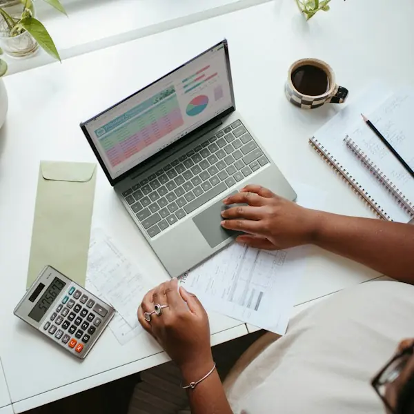 Overhead view of someone budgeting on a laptop