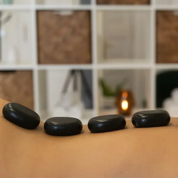 Row of smooth hot stones on a client’s back