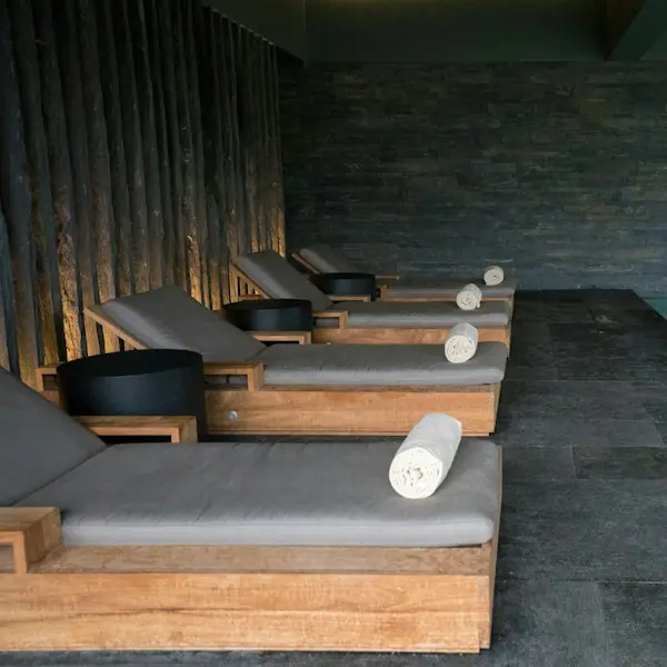 Wooden loungers with rolled towels in a spa relaxation area