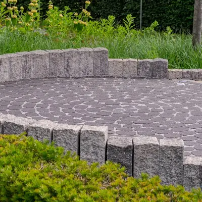 Circular paver patio edged with a low stone wall